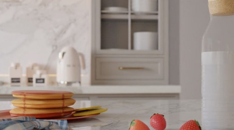 Et moderne kjøkken med fokus på et gullfarget håndtak på en skuff.